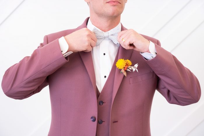 Groom Tying White Bow Tie with Light Maroon Suit for Groom's Attire for a Citrus Wedding