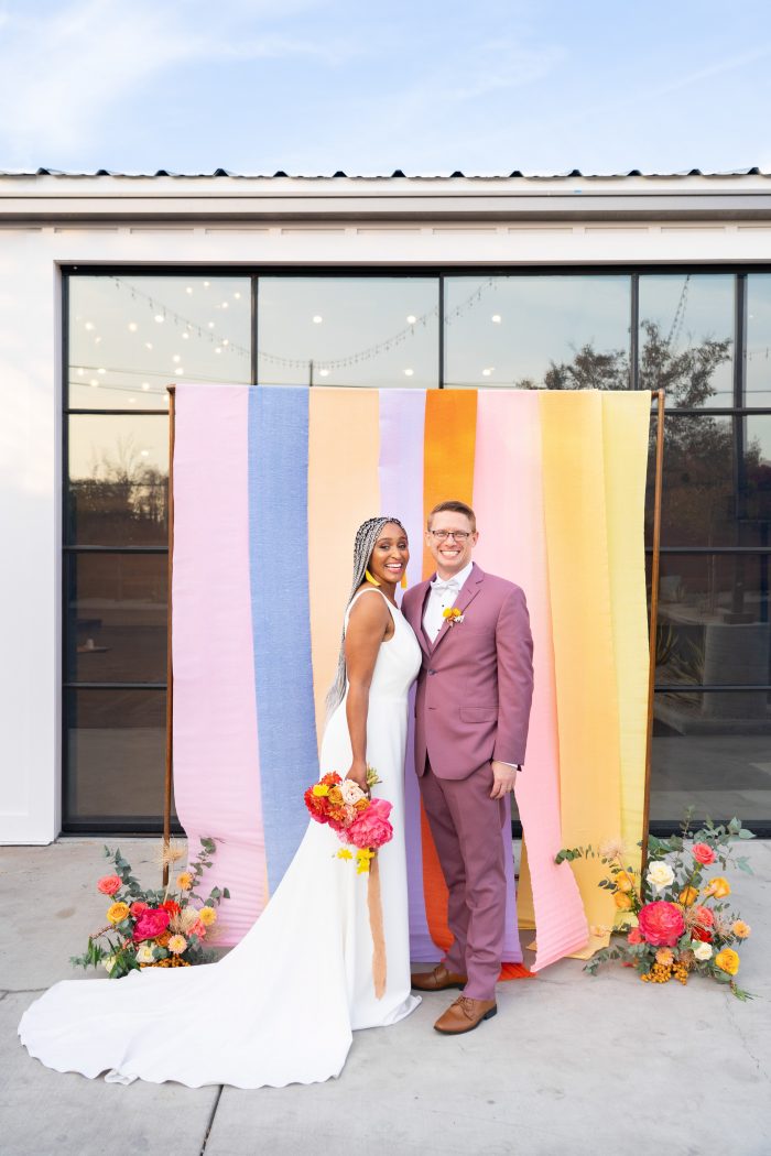 Bride and Groom in Front of Color Block Backdrop at Outdoor Wedding Ceremony