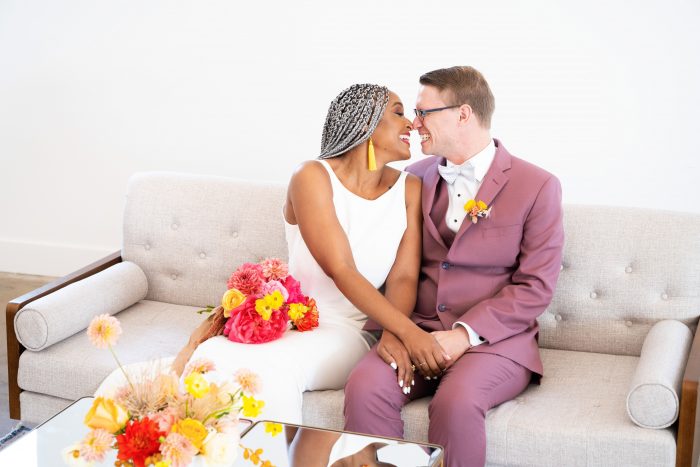 Groom on Couch with Real Bride Wearing Minimalist Wedding Dress at Reception