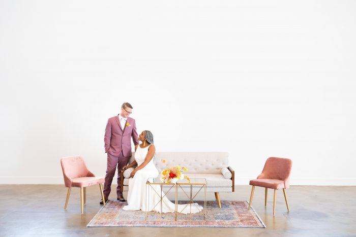 Bride and Groom on Couch with Bride Wearing Minimalist Wedding Dress at Reception