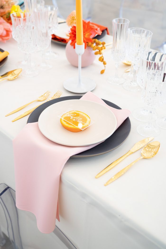 Colorful and Vibrant Table Settings with Pink Napkin at Citrus Wedding