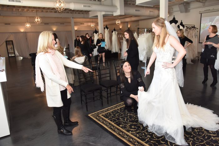 Bridal Consultants Assisting Bride in Wedding Dress Fitting