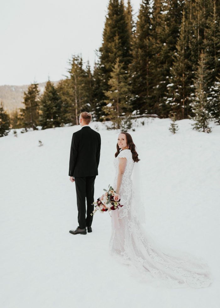 Groom During First Look with Bride Wearing Modest Sleeved Wedding Dress in the Snow