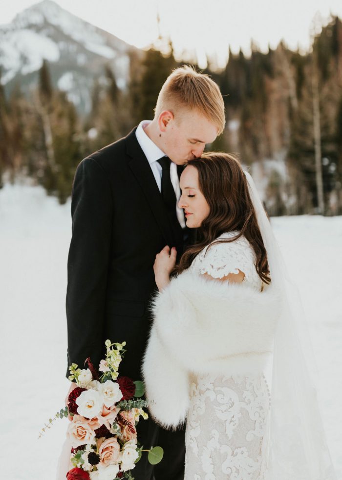 Groom Kissing Bride Wearing Maggie Sottero Wedding Dress and Ivory Fur Wrap