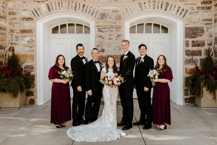Bride Wearing Maggie Sottero Wedding Dress and Standing with Wedding Party Wearing Winter Wedding Attire