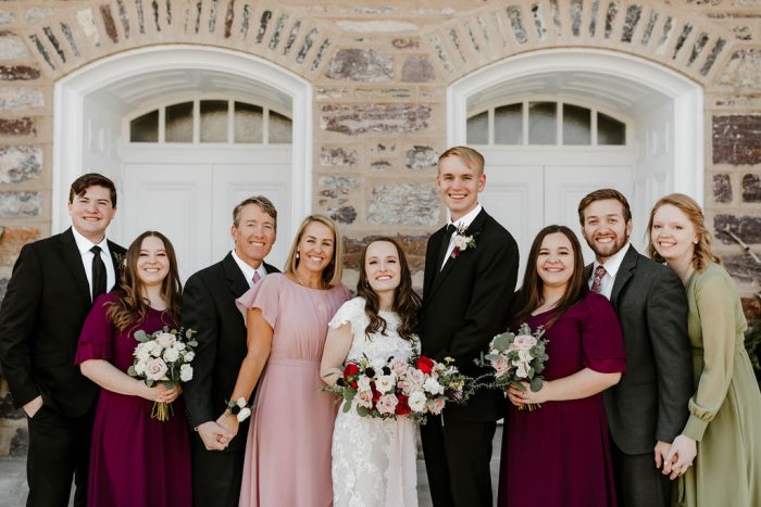 Bride and Groom Standing with Their Wedding Party at Rustic Winter Wedding