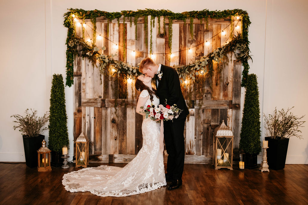 Groom Kissing Bride Wearing Modest Lace Wedding Dress by Maggie Sottero at Rustic Winter Wedding