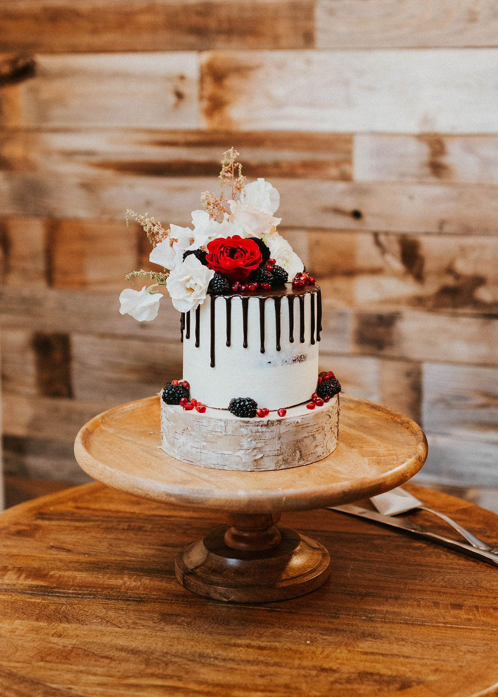 Semi-Naked Chocolate Drip Wedding Cake with Berries and Roses on Top