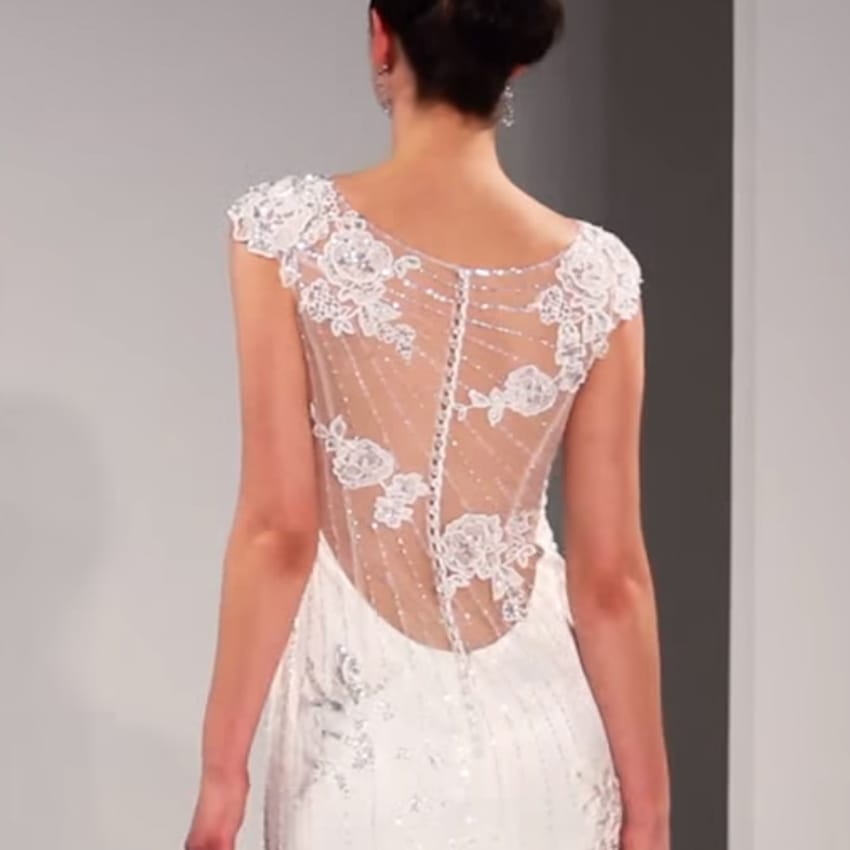 A Model Walking Down the Runway in Backless Wedding Dress by Maggie Sottero
