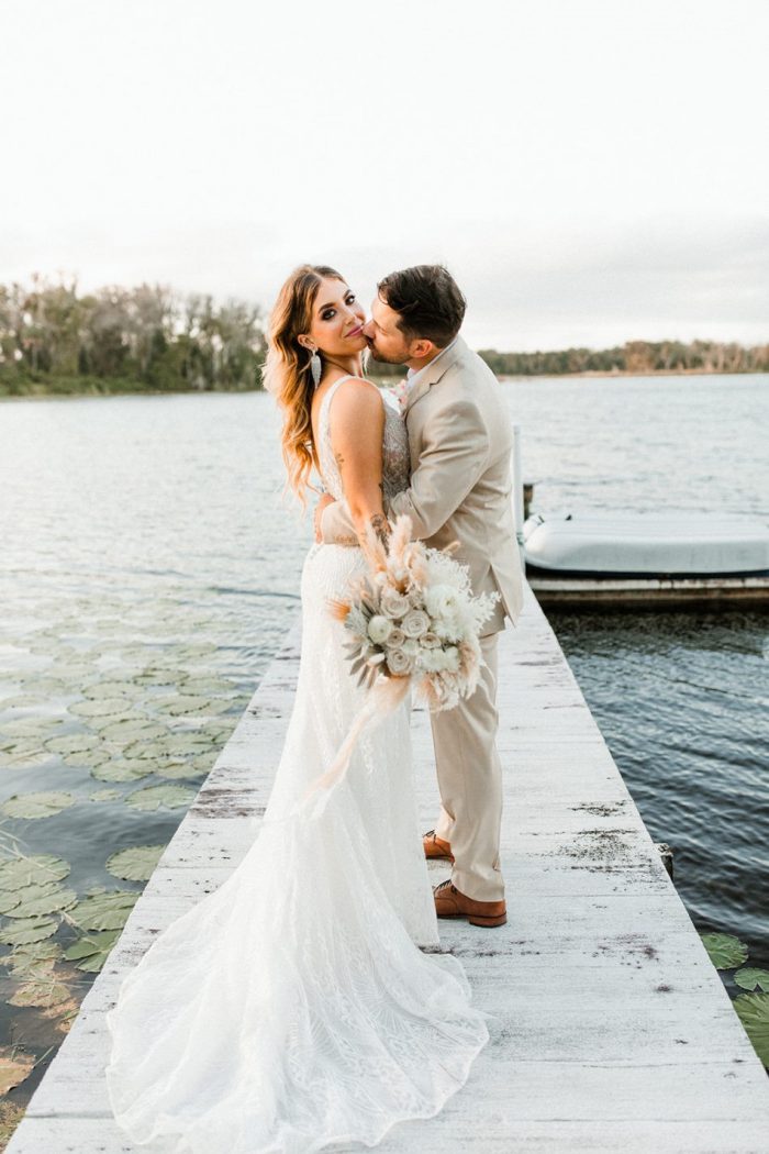Groom on Dock Kissing Real Bride Wearing Art Deco Wedding Gown called Elaine by Maggie Sottero