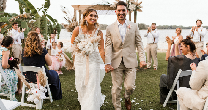 Real Bride Kaley Wearing Maggie Sottero Wedding Dress and Walking Down the Aisle with Groom at Lakeside Wedding
