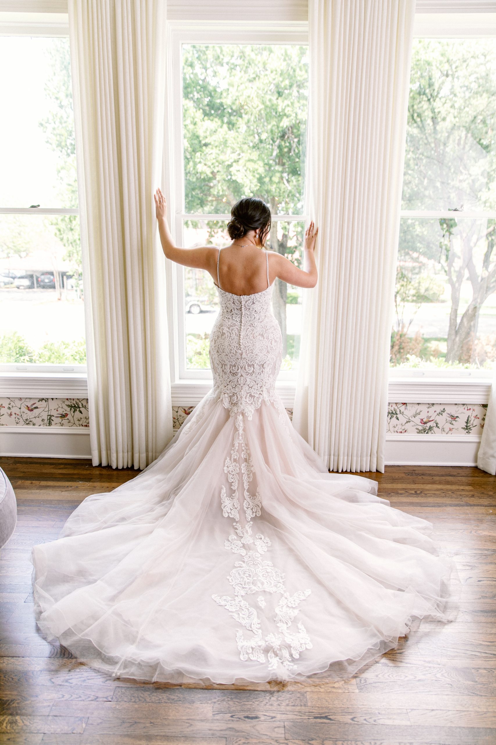La mariée porte une robe de mariée sirène appelée Alistaire Lynette par Maggie Sottero dans une salle de bal