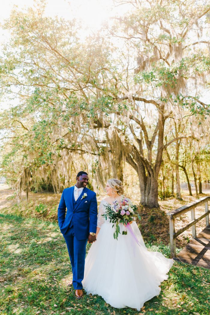 Groom Walking with Bride Wearing Lace Ball Gown Wedding Dress Called Mallory Dawn by Maggie Sottero During First Look