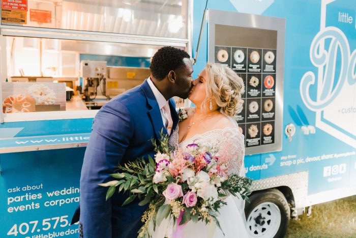 Bride and Groom Kissing in Front of Homemade Donut Truck at Spring Wedding