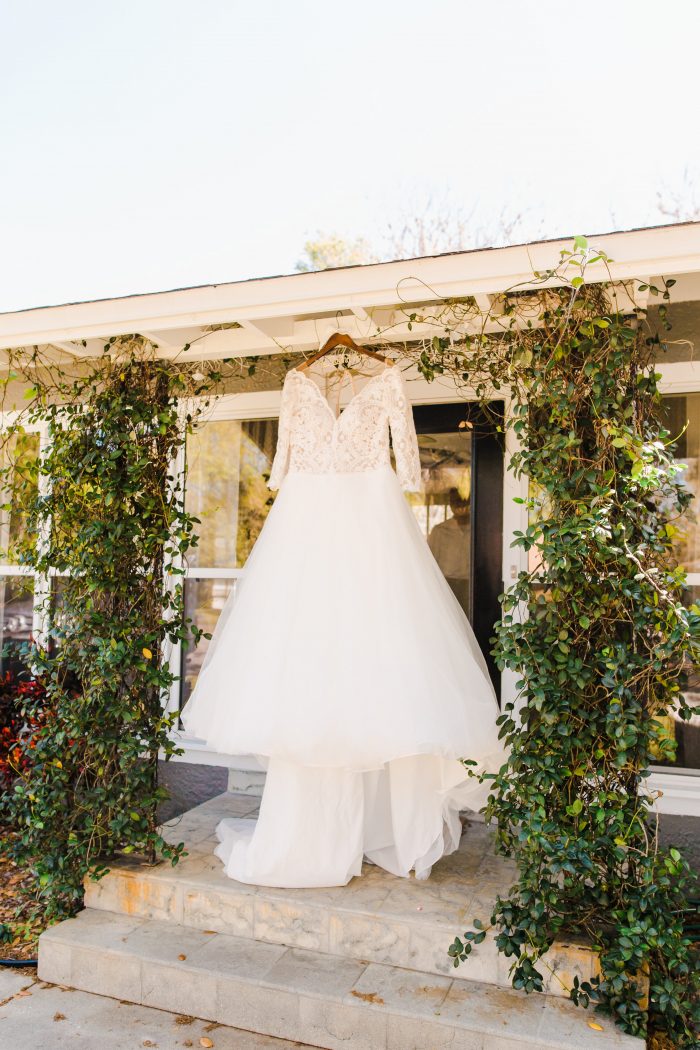 Lace Ball Gown Wedding Dress Called Mallory Dawn by Maggie Sottero Hanging from Doorway Outside
