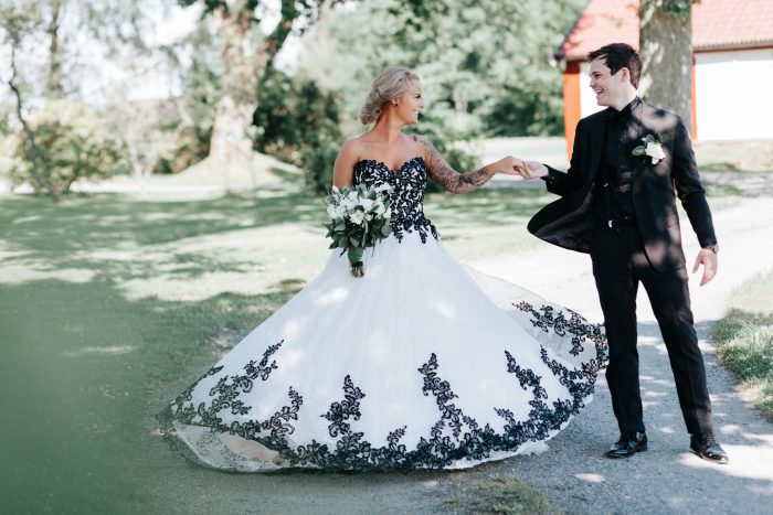 Bride Standing With Groom Wearing A Black Wedding Dress Called Tristyn By Sottero And Midgley