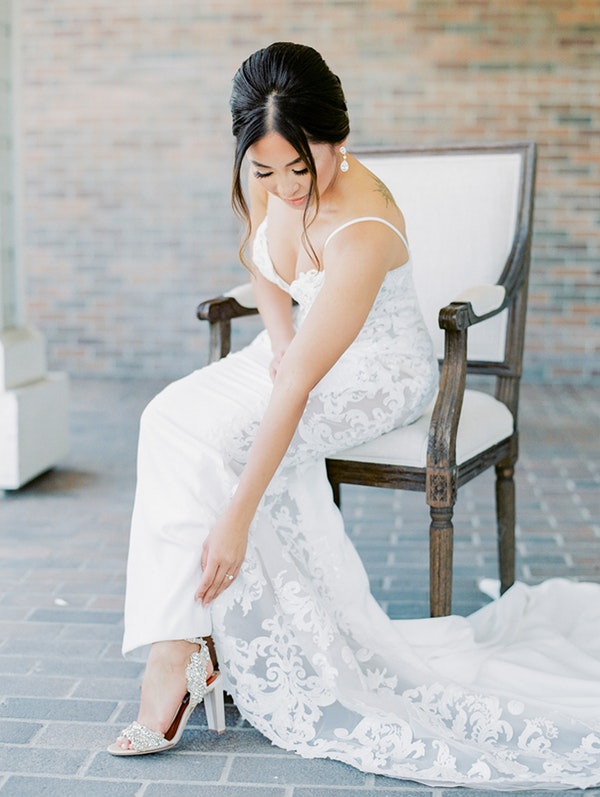 Bride Putting on Shoe and Wearing Soft Updo