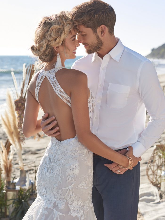 Groom with Bride on Beach Wearing Affordable Sexy Backless Mermaid Wedding Gown Called Elizabetta by Rebecca Ingram