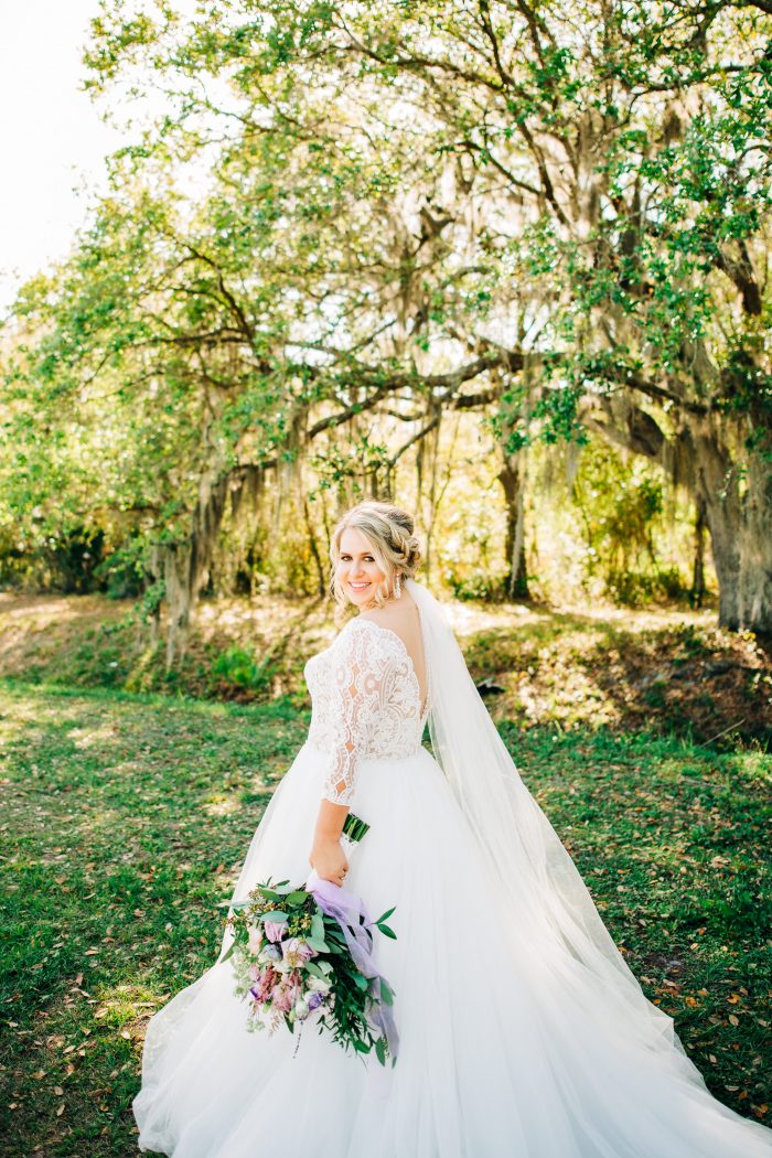 Plus Size Bride on Wedding Day Holding Bouquet and Wearing Scallop Lace Off the Shoulder Wedding Dress Called Mallory Dawn by Maggie Sottero