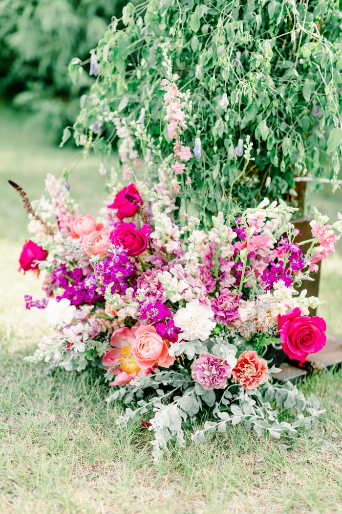 Colorful and Vibrant Florals at the Base of Rustic Wedding Arch