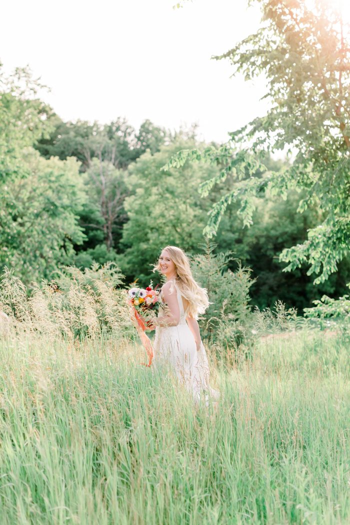 Bride Running Through Green Meadow While Wearing Boho Lace Wedding Dress Called Burke by Maggie Sottero