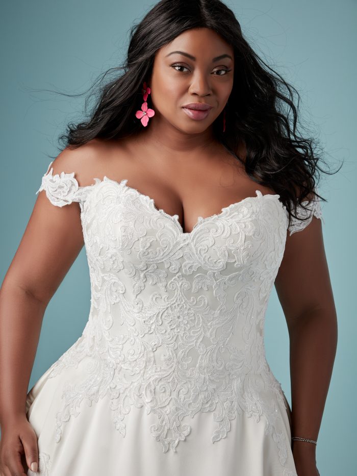 Curvy Black Bride Wearing Off-the-Shoulder Satin Ball Gown Wedding Dress Called Sheridan by Maggie Sottero with Pockets