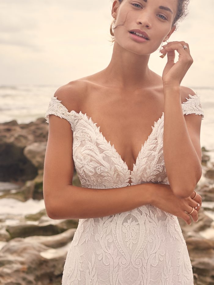 Model on Beach Wearing Cap-Sleeve Lace Mermaid Wedding Dress Called Joss by Sottero and Midgley