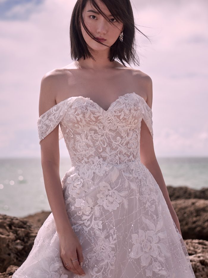 Model on Beach Wearing Fairytale Off-the-Shoulder Bridal Gown Called Parker by Sottero and Midgley