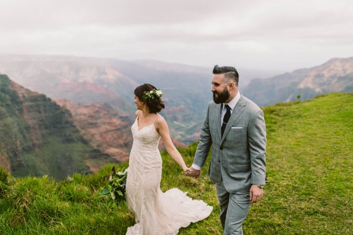 Bride and Groom Walking Along Gorgeous Mountains for Hawaii Destination Elopement