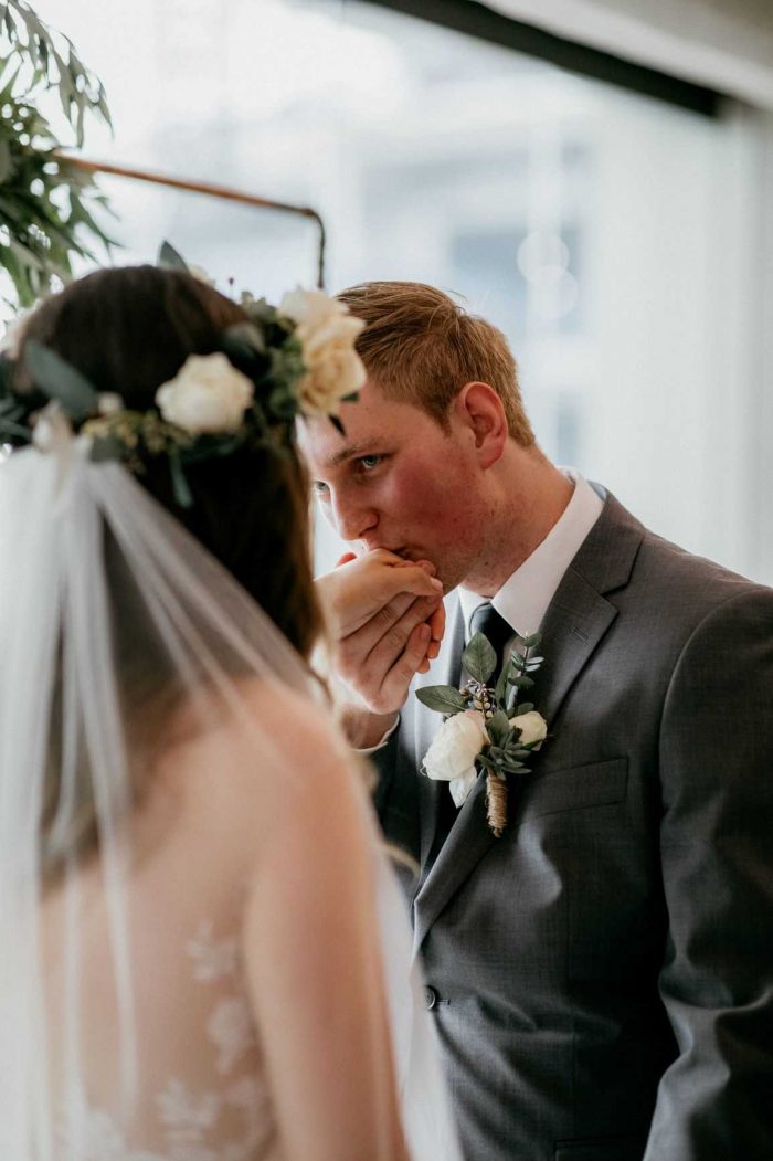Groom Kissing Bride's Hand During Wedding Ceremony