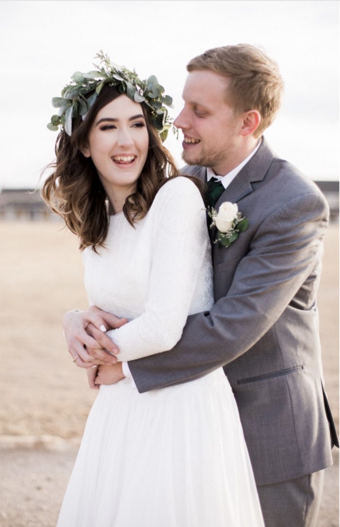 Groom Laughing with Real Bride Wearing Modest Weddinng Dress and Whimsical Flower Crown During Wedding Shoot