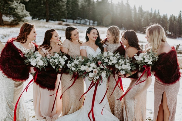 Real bride and bridesmaids holding bouquet of roses