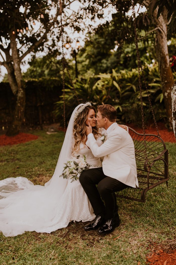 Groom on Bench Kissing Real Bride Wearing Boho Wedding Dress Called Antonia by Maggie Sottero