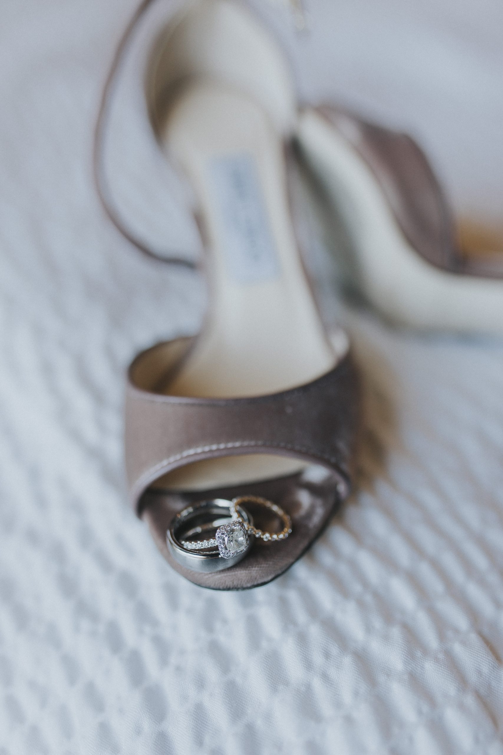 Bague de fiançailles et alliance dans une chaussure de mariée à bout ouvert