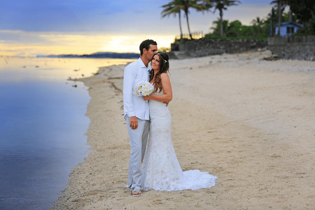 Groom with Real Bride Wearing Maggie Sottero Wedding Dress on the Beach