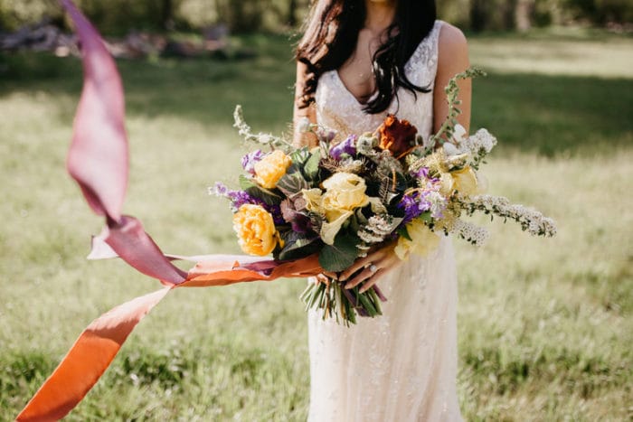 Bride Holding Colorful Wedding Bouquet in Field