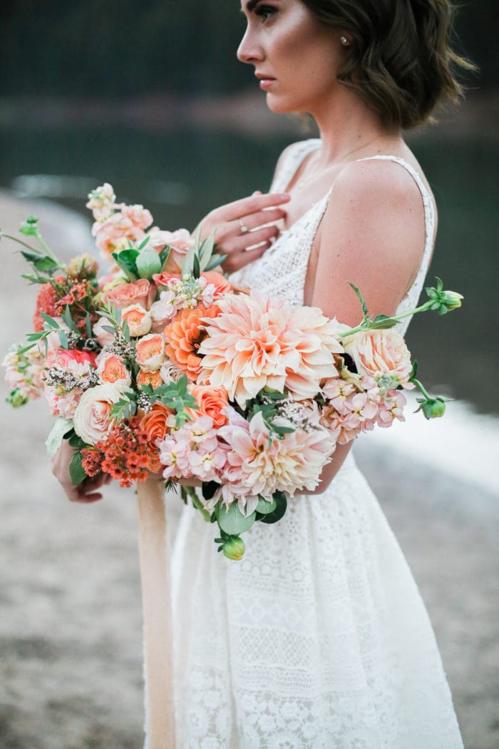 Bride on the beach holding a colorful wedding bouquet