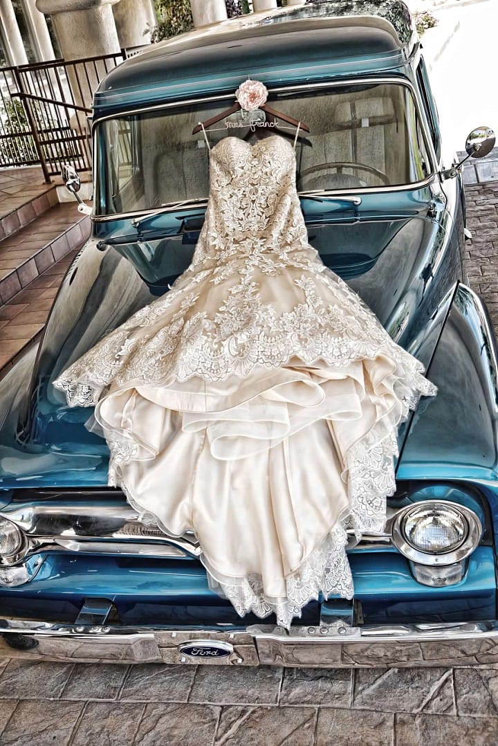 Elegant Celebration with Lace Wedding Gown, Classic Cars, and Flirty Details. Jennita wedding dress by Maggie Sottero.