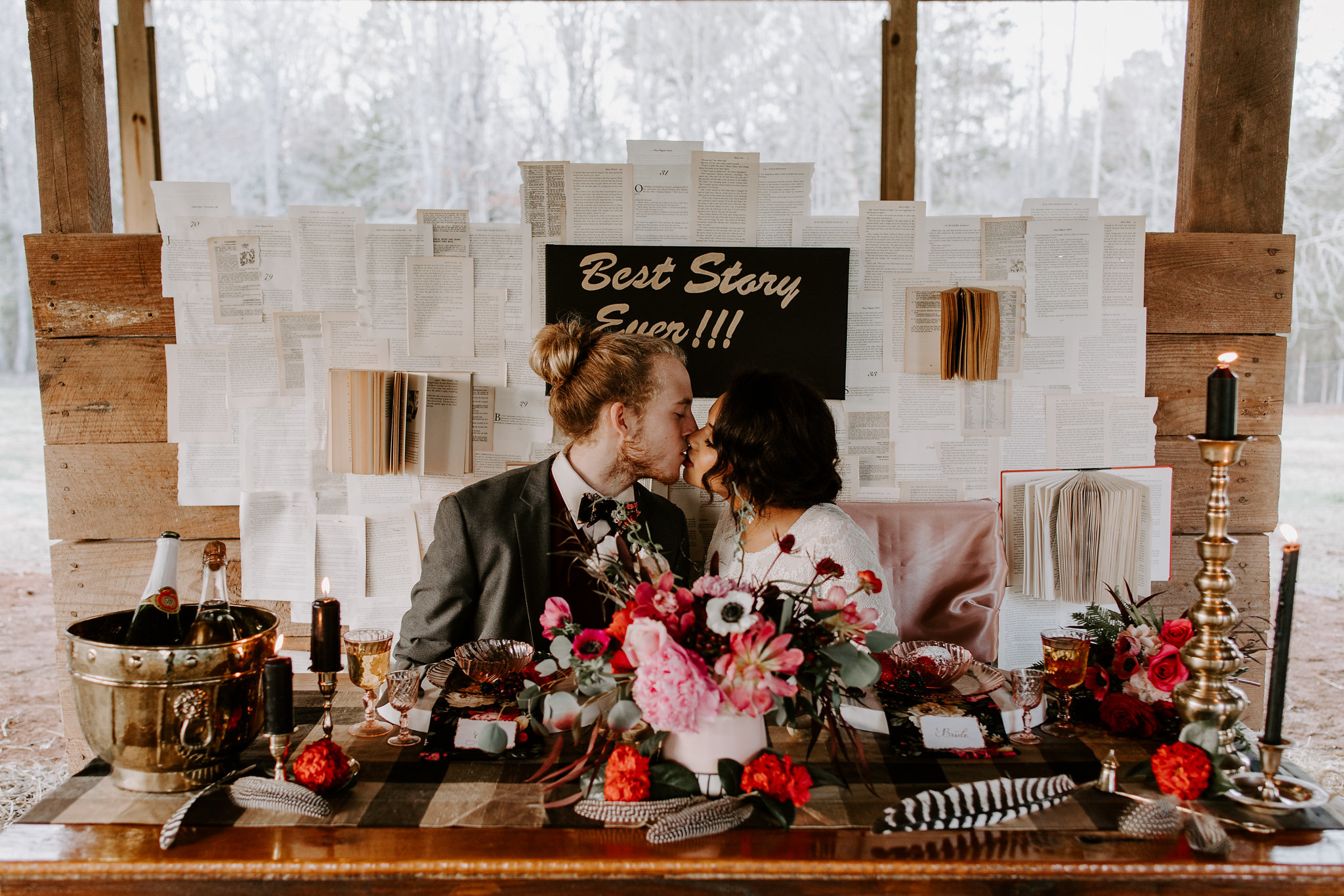 Bride and Groom Kissing Behind Table Decorated with Red Dining Ware and Red Cake for Valentine's Day