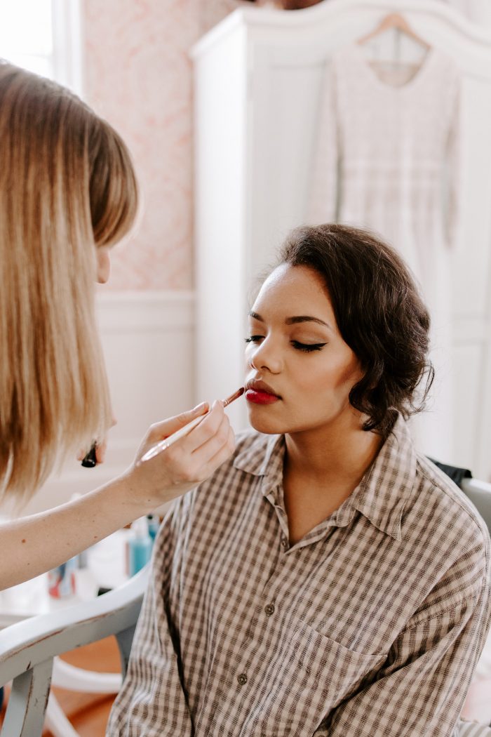 Makeup Stylist Putting on Bride's Red Lipstick