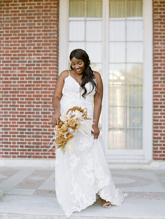 Black Bride Wearing Lace A-line Wedding Dress Called Tuscany Lane by Maggie Sottero and Holding Autumn Wedding Bouquet