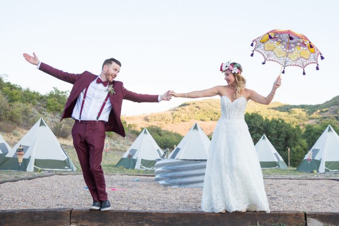 Bride wearing Watson lace dress by Sottero and Midgley and Groom with tents and a colorful parasol