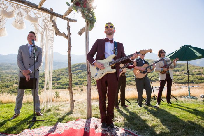 Groom with a guitar at an outdoor wedding