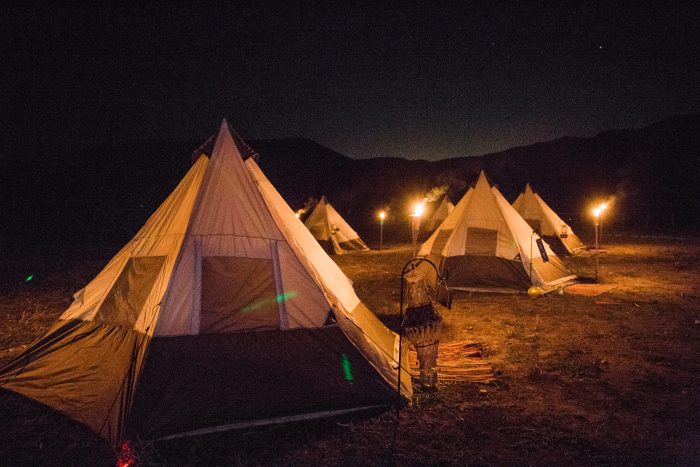 Teepees lit up at night