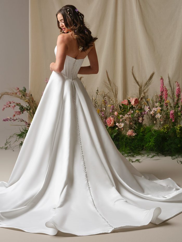 Back view of Rebecca Ingram Alexia wedding dress featuring a structured corset bodice, covered buttons, and a sweeping satin train.