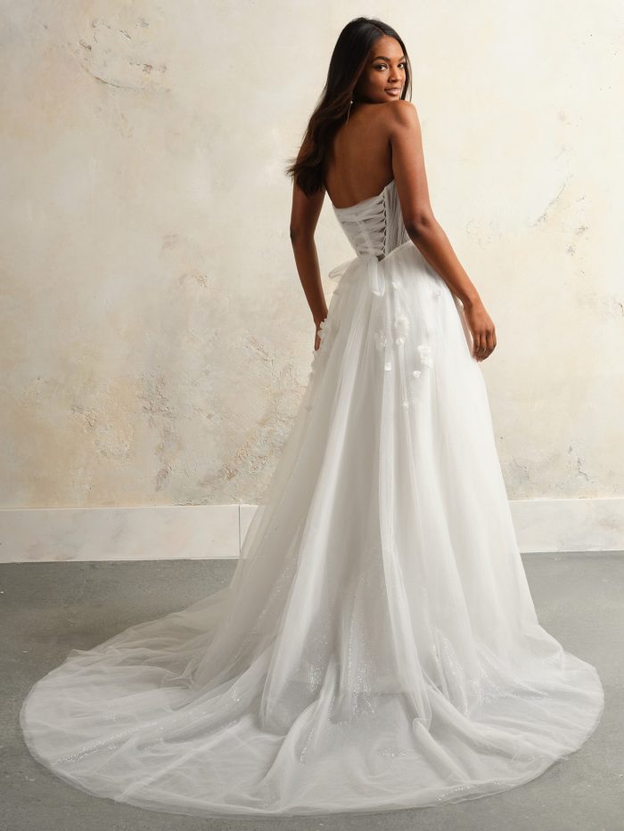 Back view of Rebecca Ingram Allison wedding dress featuring a lace-up corset back, 3D floral details, and a flowing tulle train.