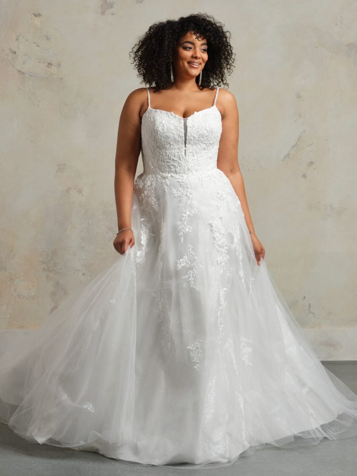 Rebecca Ingram Catherine A-line wedding dress featuring a sweetheart neckline, delicate straps, floral lace appliqués, and a full tulle skirt.