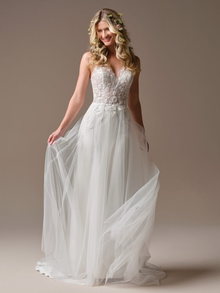 Rebecca Ingram Holly wedding dress featuring a plunging V-neckline, floral lace bodice, and flowing tulle skirt.