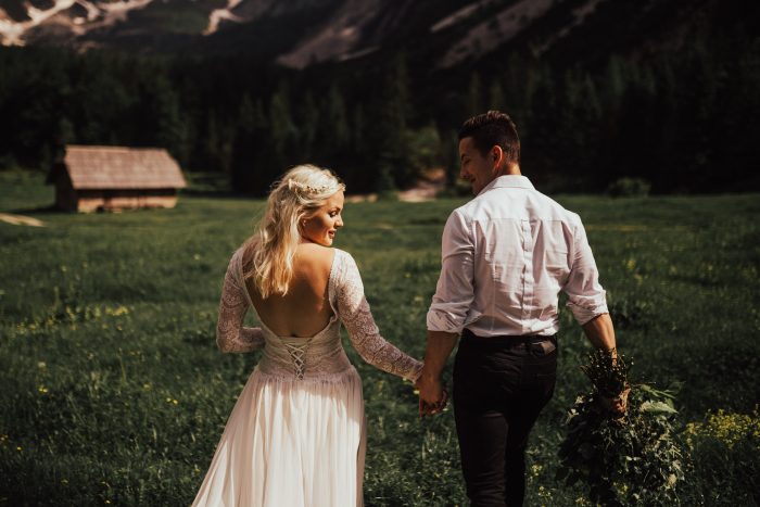 Couple walking through a field in the mountains