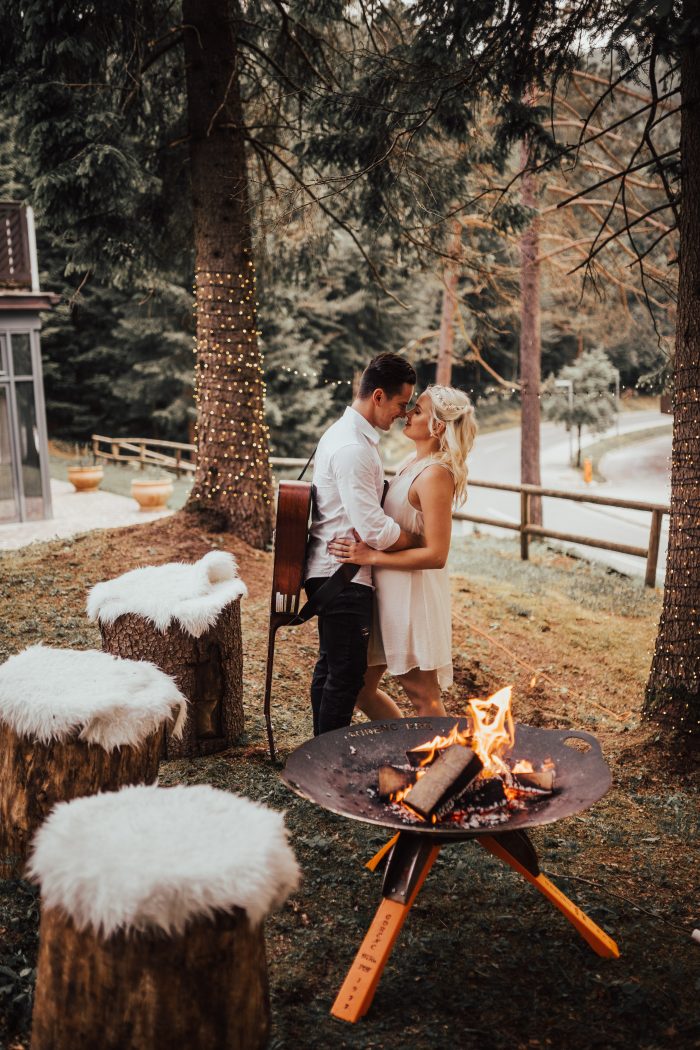 Couple in the woods next to a fire